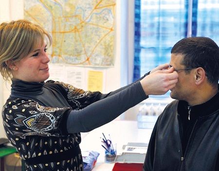 Opticienne qui remet une paire de lunettes à un patient